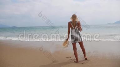 穿着黑白衣服的年轻女子独自走在热带<strong>海滩</strong>上，看着海上的<strong>暴风雨</strong>。 旅费